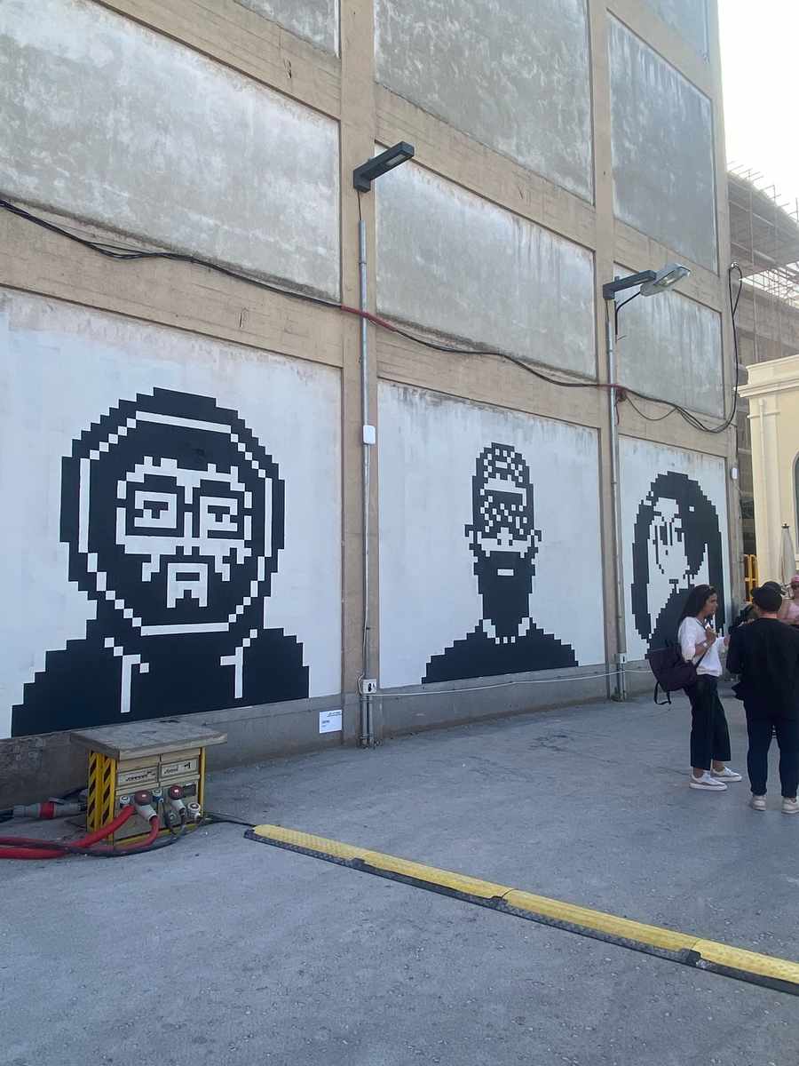 Pixel art CryptoPunk-style murals painted on warehouse walls at NFC Summit 2026 Lisbon